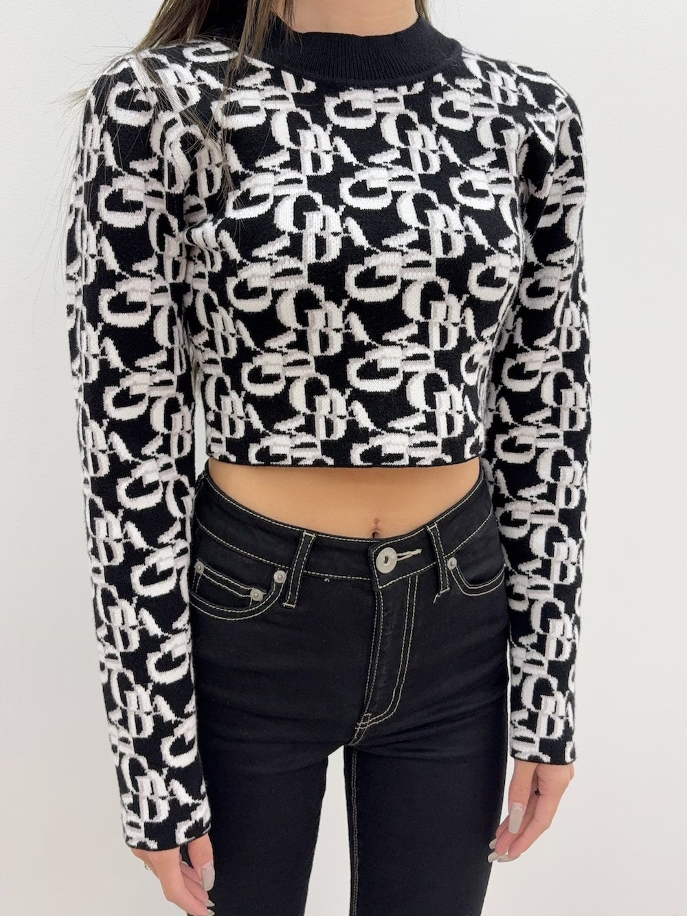 ブラック系のデニムパンツ、ブラック系のブーツ、ブラック系のニット/セーターを着用したレディースの秋コーディネートの4枚目の写真