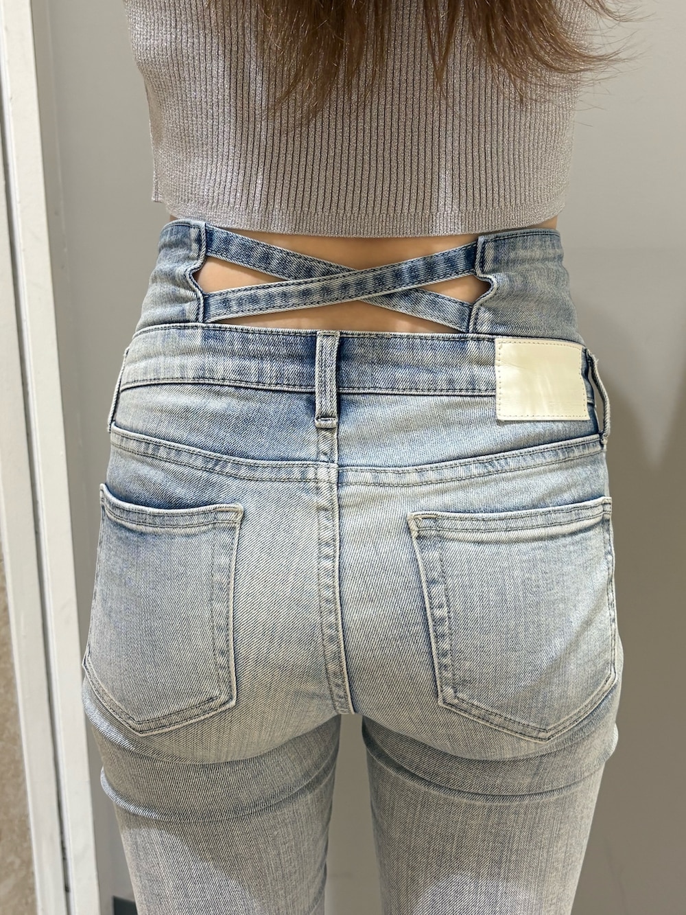 シルバー系のニット/セーター、ブルー系のデニムパンツ、ホワイト系のパンプスを着用したレディースの春コーディネートの6枚目の写真