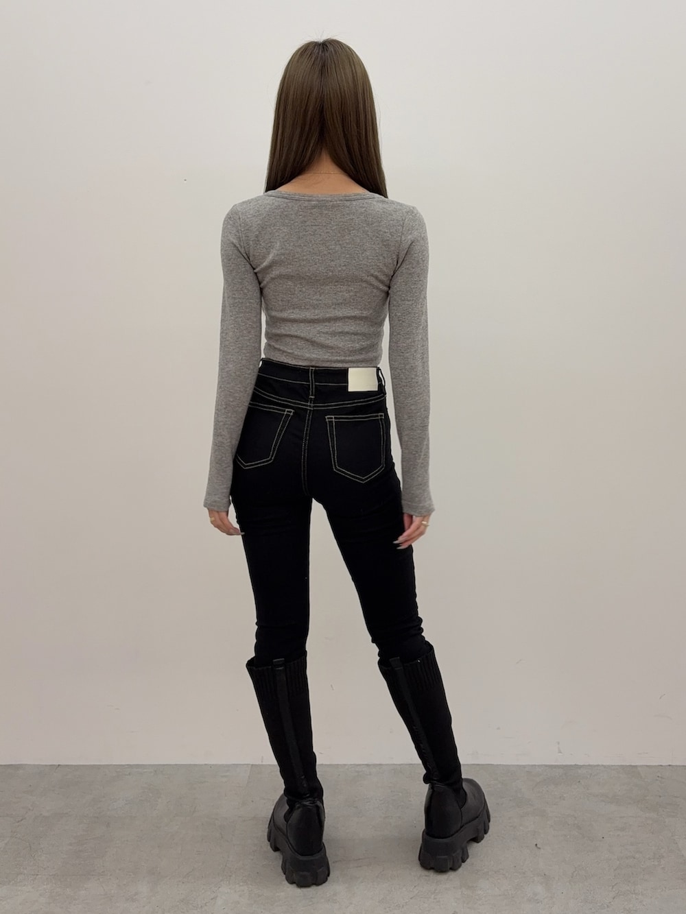 グレー系のTシャツ/カットソー、ブラック系のデニムパンツ、ブラック系のブーツを着用したレディースの秋コーディネートの3枚目の写真