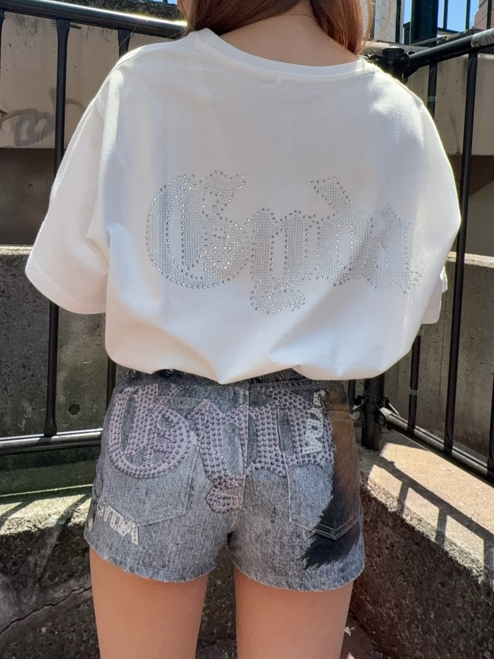 ホワイト系のTシャツ/カットソー、ブルー系のデニムパンツ、ホワイト系のサンダルを着用したレディースの夏コーディネートの4枚目の写真