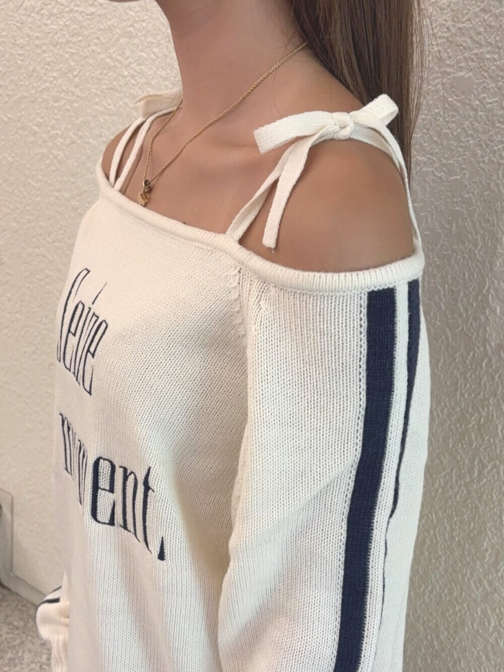 ブラック系のブーツ、ブラック系のスカート、ホワイト系のニット/セーターを着用したレディースの秋コーディネートの4枚目の写真