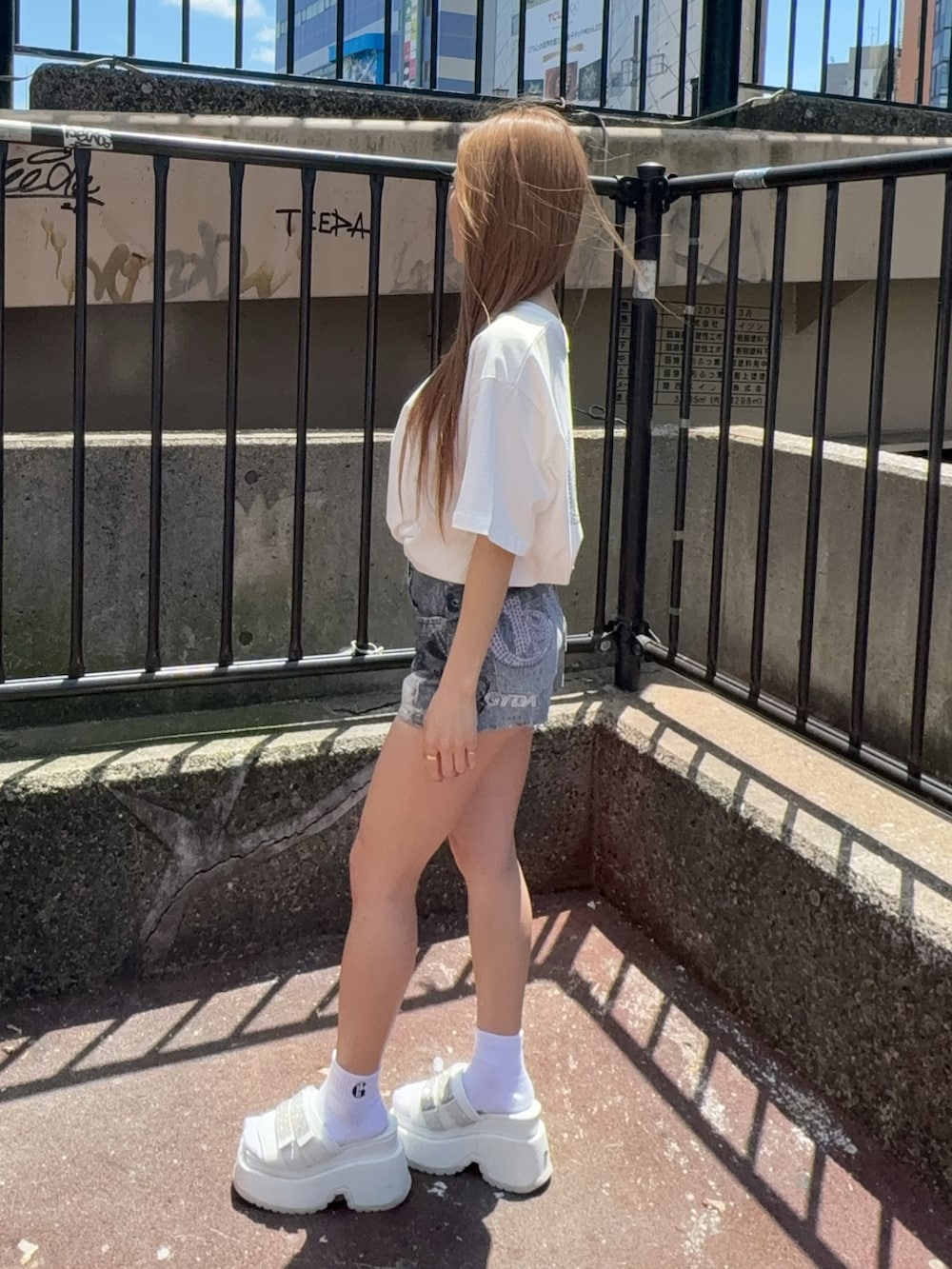 ホワイト系のTシャツ/カットソー、ブルー系のデニムパンツ、ホワイト系のサンダルを着用したレディースの夏コーディネートの2枚目の写真