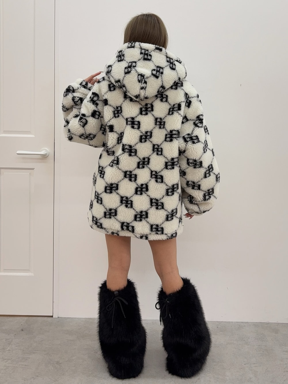 ブラック系のニット/セーター、ブルー系のデニムスカート、ブラック系のブーツを着用したレディースの秋コーディネートの3枚目の写真