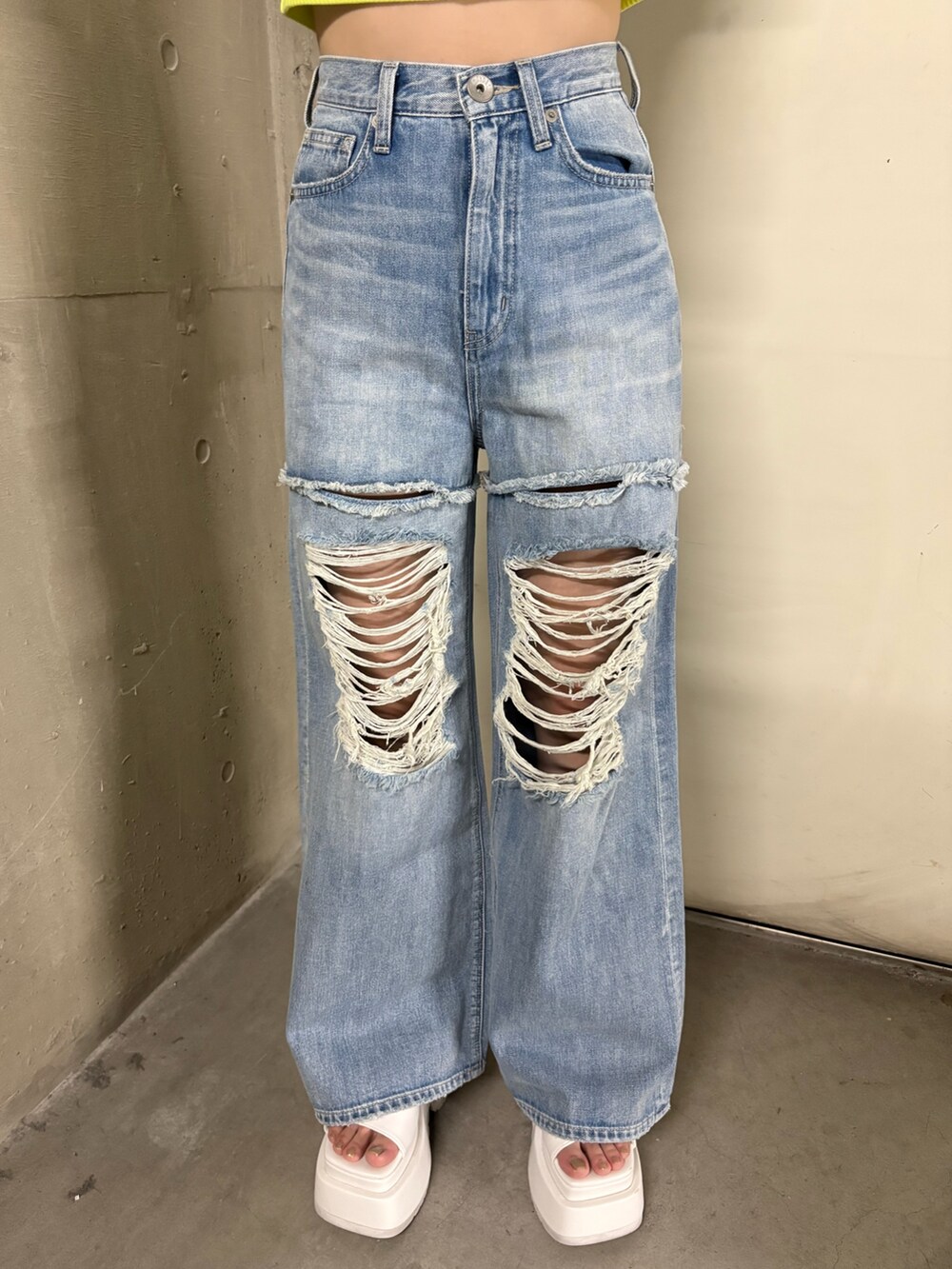 ブルー系のデニムパンツ、ホワイト系のサンダル、グリーン系のTシャツ/カットソーを着用したレディースの春コーディネートの5枚目の写真