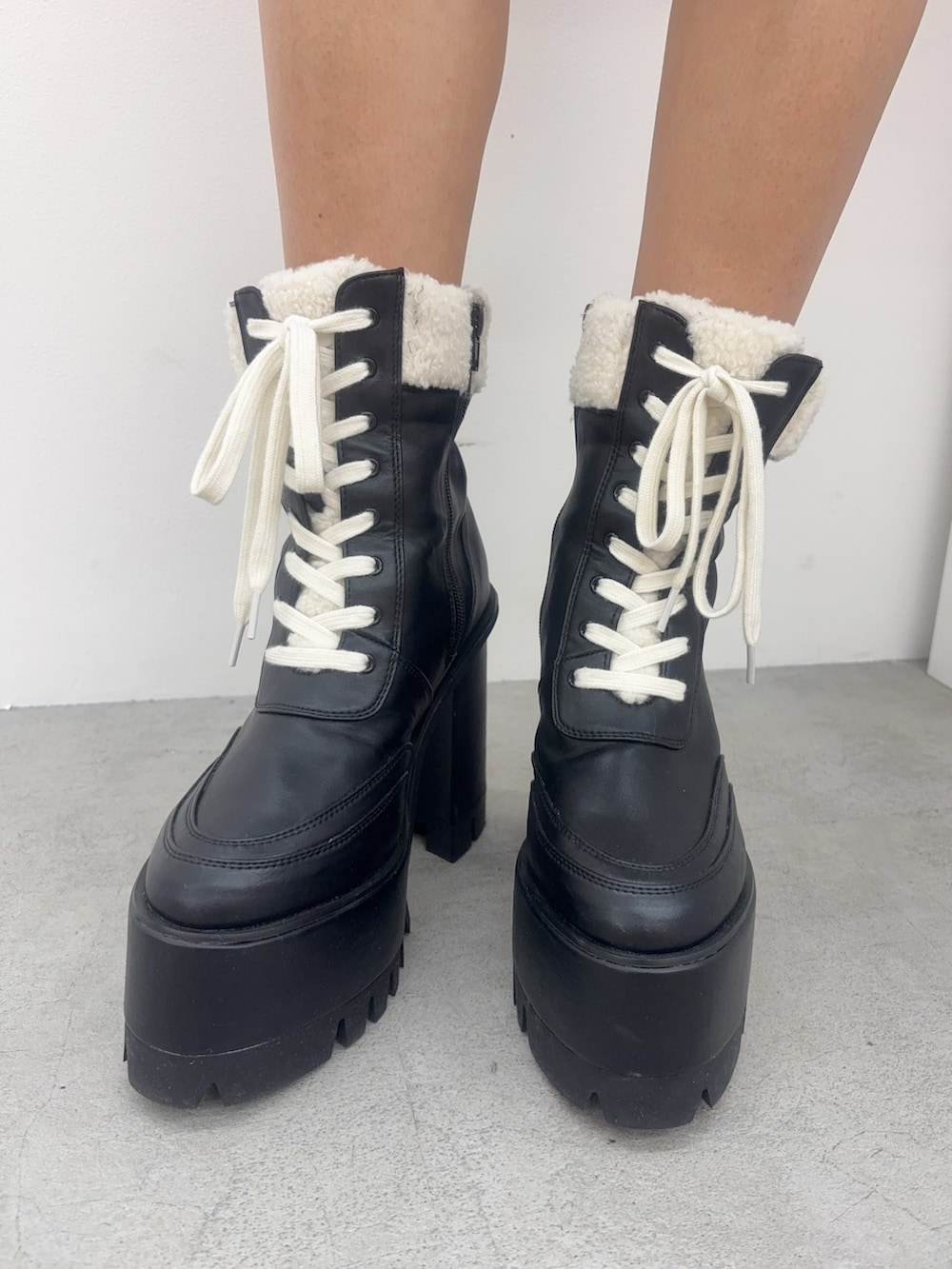 ホワイト系のTシャツ/カットソー、ブラック系のブーツ、ブラウン系のブルゾンを着用したレディースの冬コーディネートの5枚目の写真