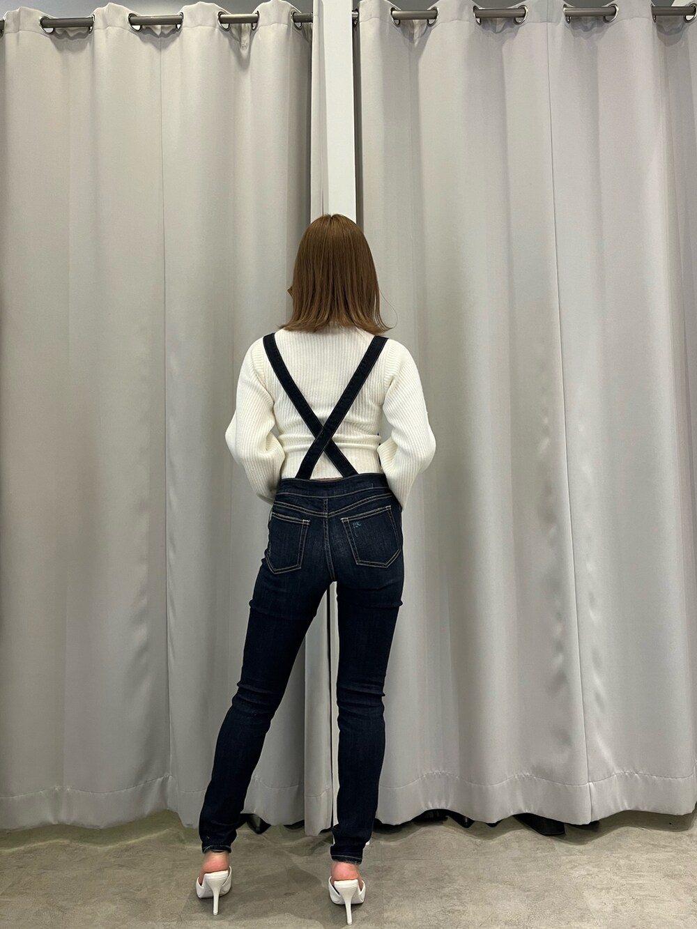 ホワイト系のブルゾン、ホワイト系のニット/セーター、ブルー系のつなぎ/オールインワンを着用したレディースの冬コーディネートの6枚目の写真