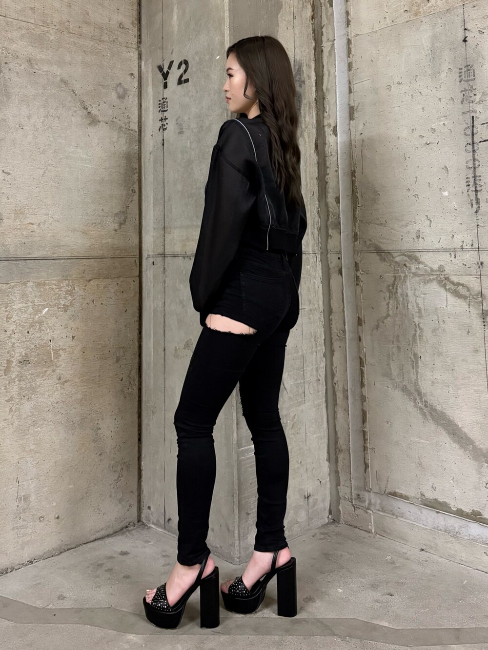 ブラック系のブルゾン、ブルー系のキャミソール、ブラック系のデニムパンツを着用したレディースの春コーディネートの2枚目の写真