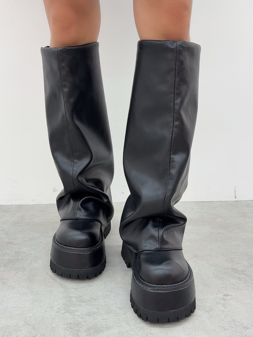 ピンク系のニット/セーター、ブルー系のデニムスカート、ブラック系のブーツを着用したレディースの秋コーディネートの5枚目の写真