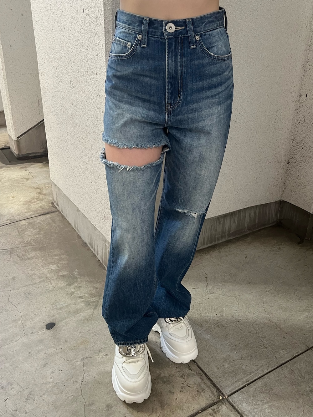 ホワイト系のTシャツ/カットソー、ホワイト系のハンドバッグ、ブルー系のデニムパンツを着用したレディースの春コーディネートの6枚目の写真