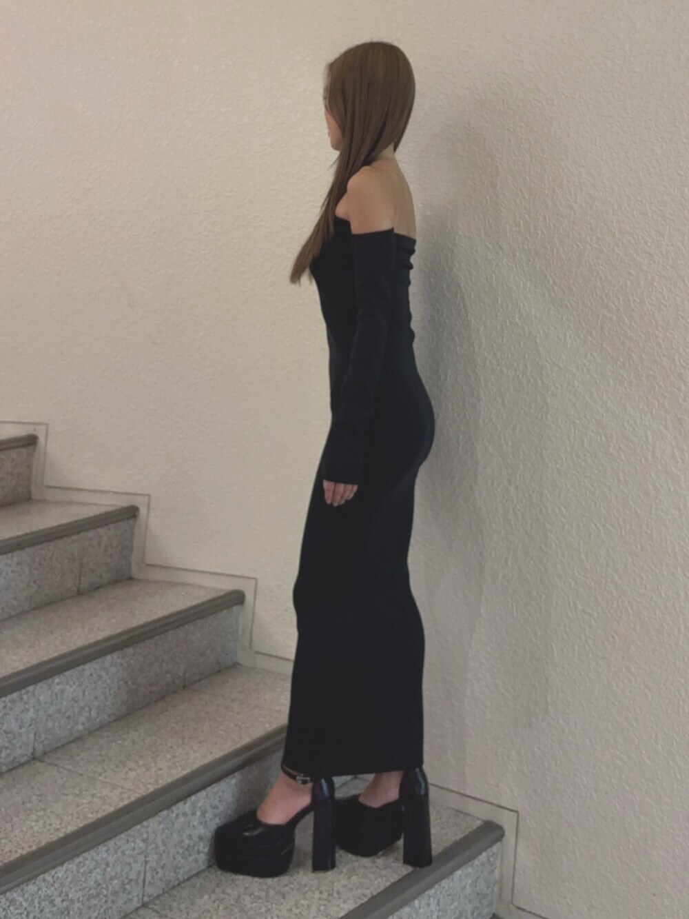 ブラック系のワンピース、ブラック系のパンプスを着用したレディースの秋コーディネートの2枚目の写真