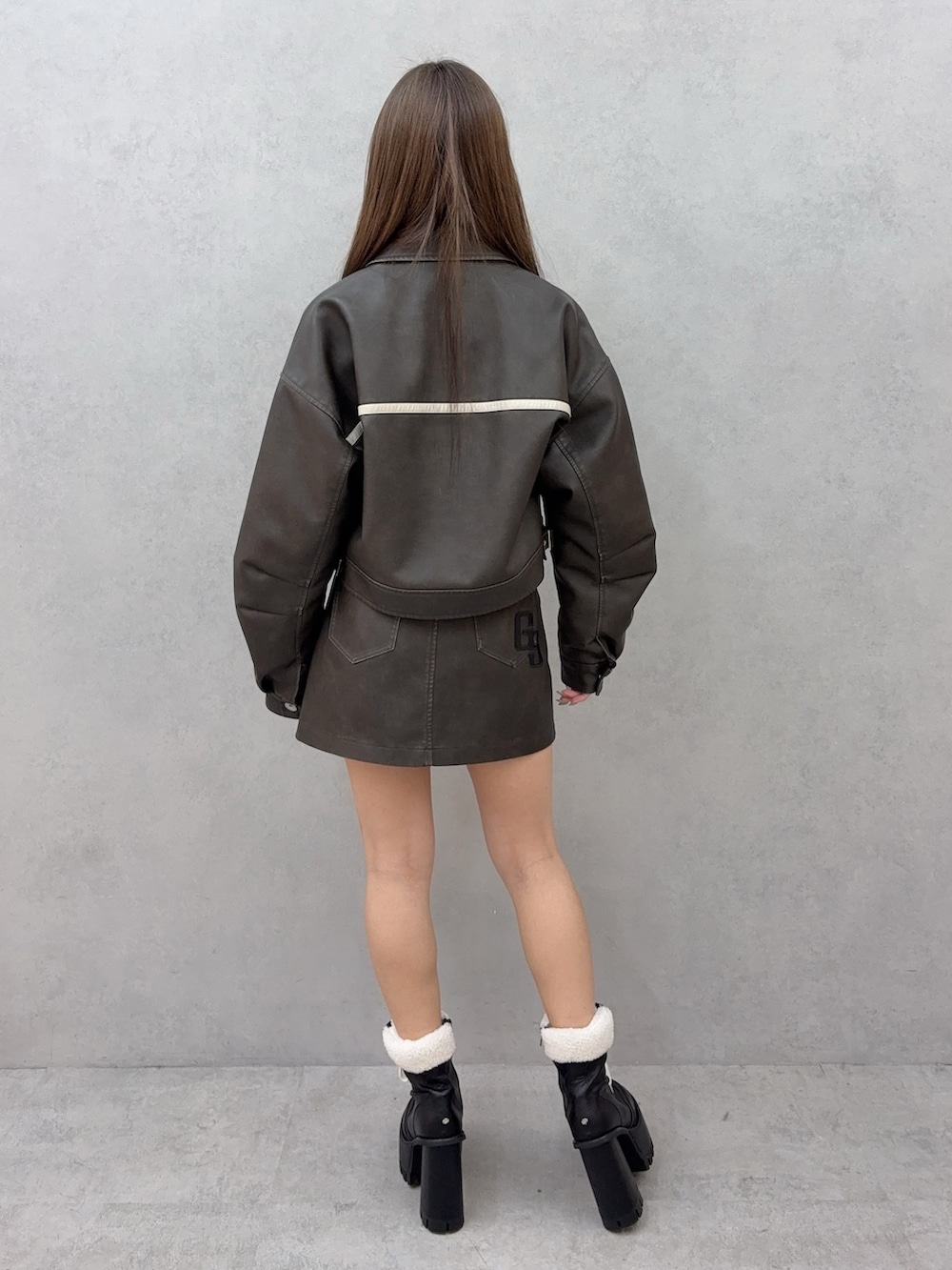 ホワイト系のTシャツ/カットソー、ブラック系のブーツ、ブラウン系のブルゾンを着用したレディースの冬コーディネートの3枚目の写真