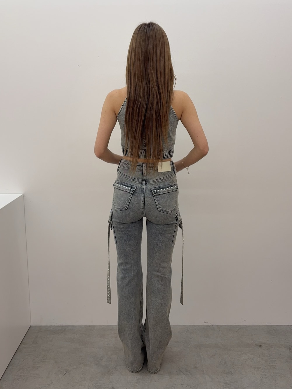ブルー系のタンクトップ、ブルー系のデニムパンツ、ホワイト系のサンダルを着用したレディースの春コーディネートの3枚目の写真