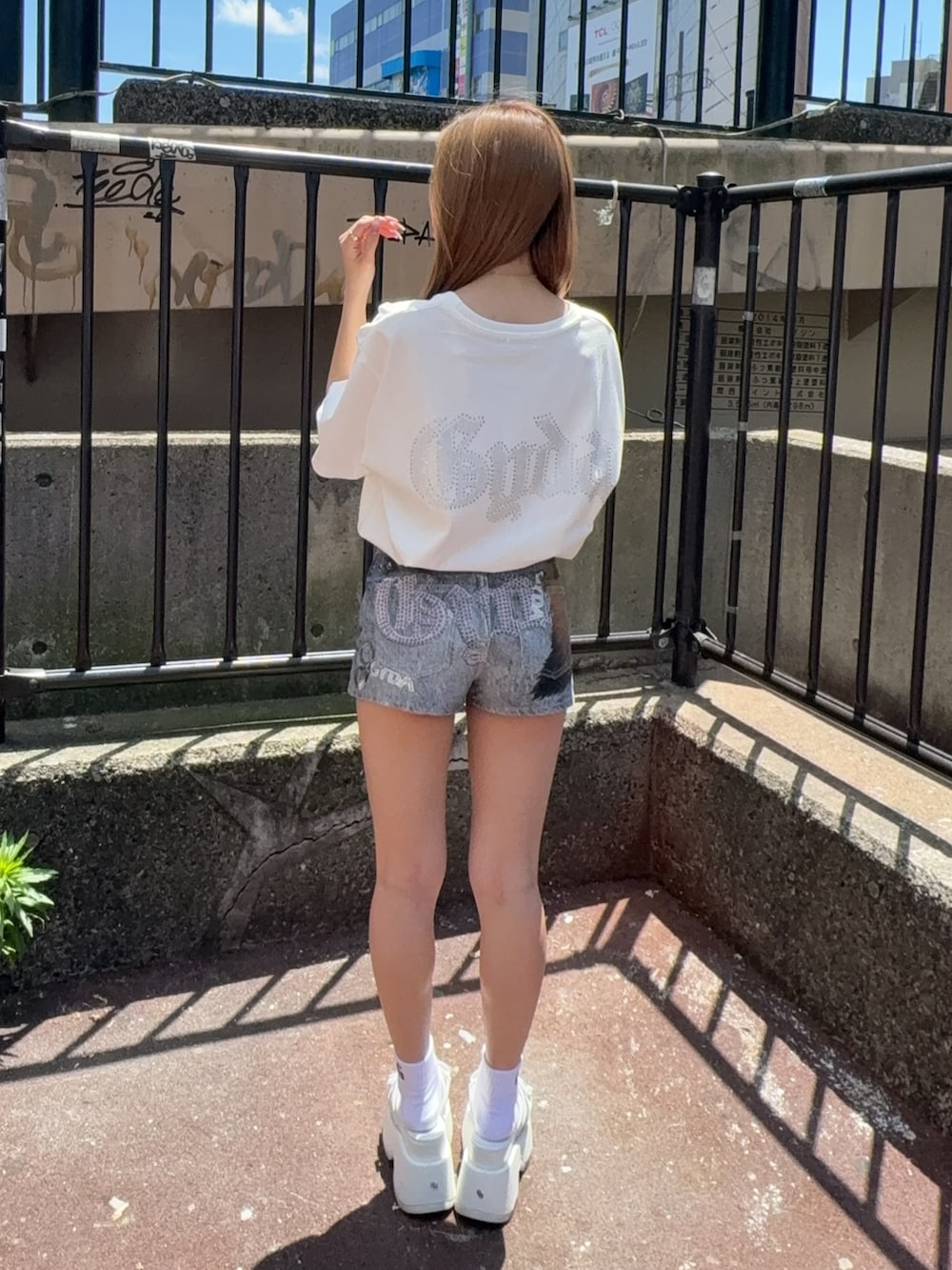 ホワイト系のTシャツ/カットソー、ブルー系のデニムパンツ、ホワイト系のサンダルを着用したレディースの夏コーディネートの3枚目の写真