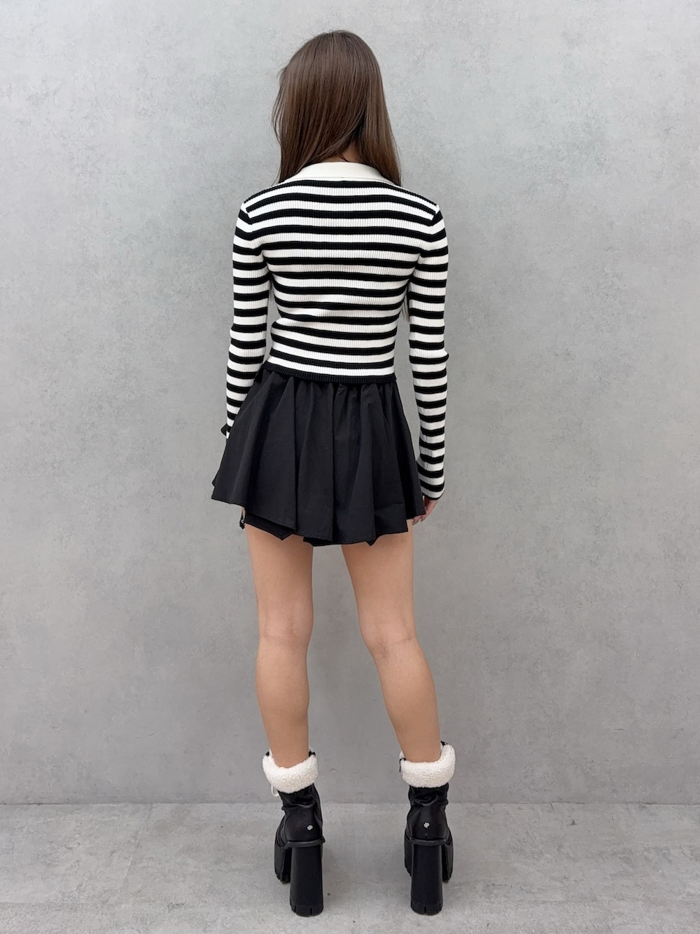 その他のニット/セーター、ブラック系のスカート、ブラック系のブーツを着用したレディースの冬コーディネートの3枚目の写真