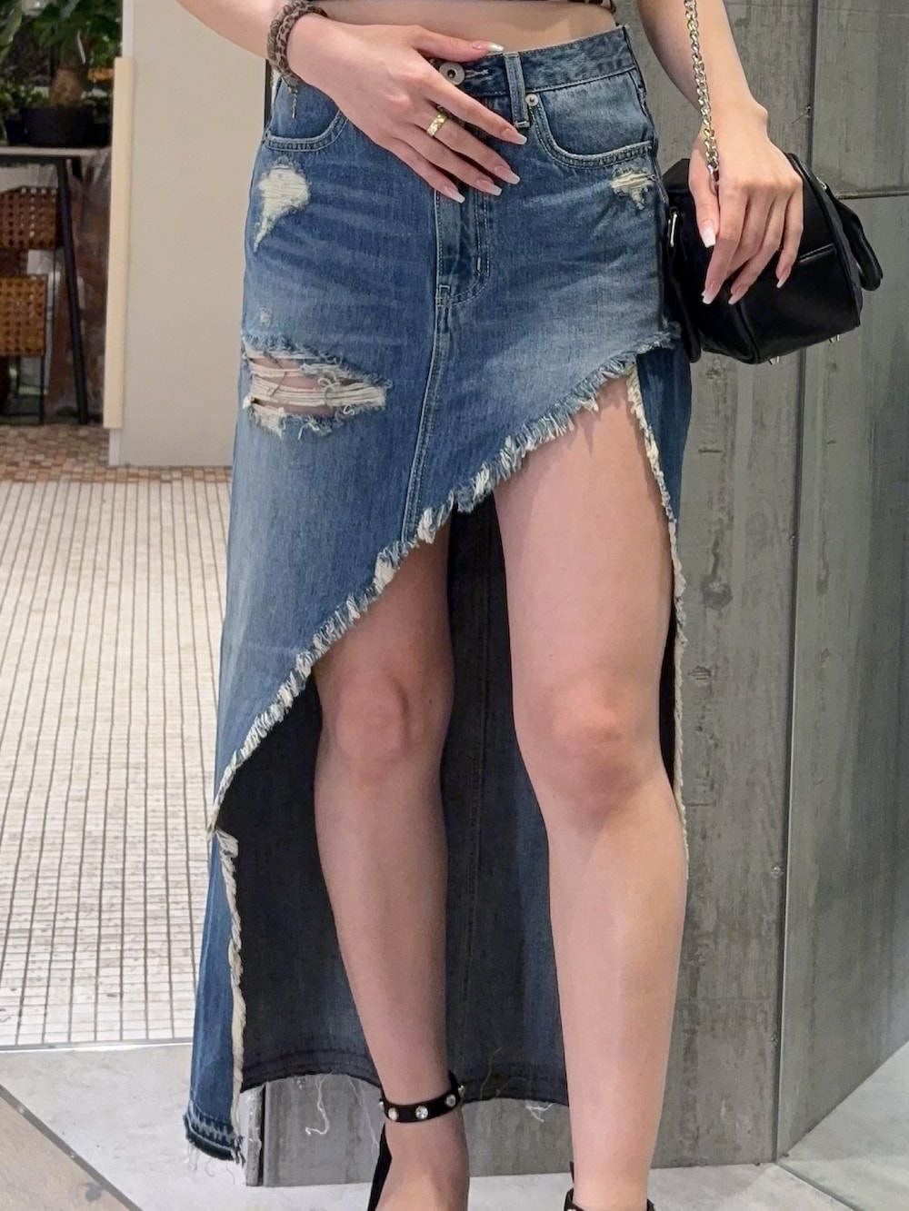 その他のキャミソール、ブラック系のサンダル、ブルー系のデニムスカートを着用したレディースの春コーディネートの5枚目の写真