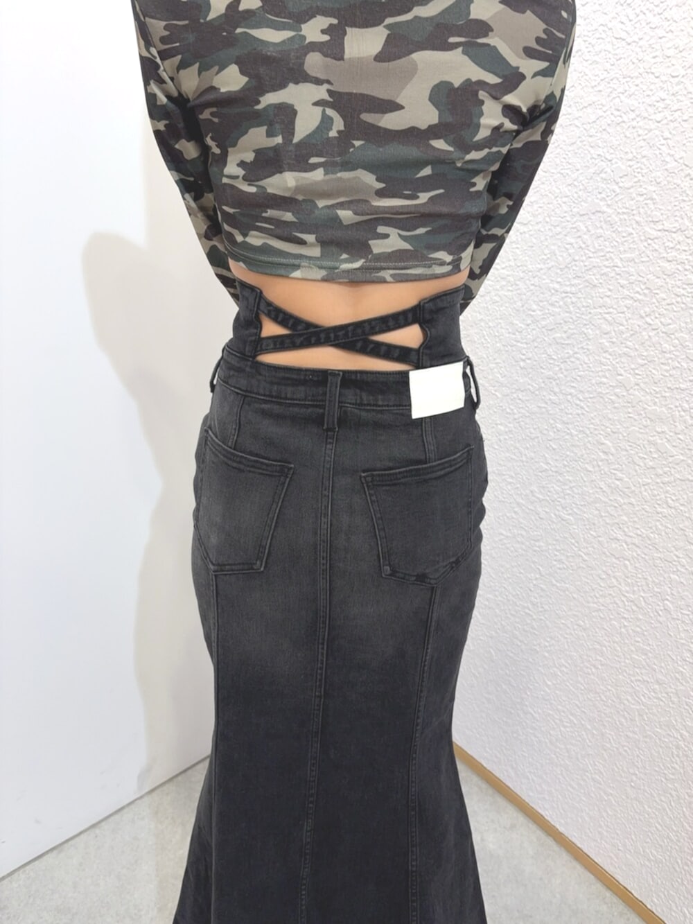 ブラック系のブーツ、レッド系のニット/セーター、ブラック系のデニムスカートを着用したレディースの秋コーディネートの6枚目の写真