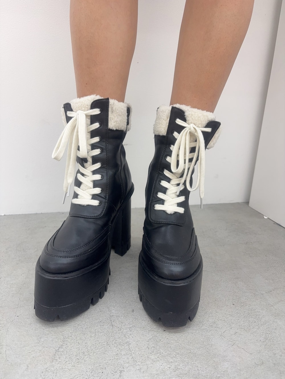 イエロー系のダウンジャケット/コート、ブラック系のブーツ、ブラック系のデニムパンツを着用したレディースの冬コーディネートの5枚目の写真