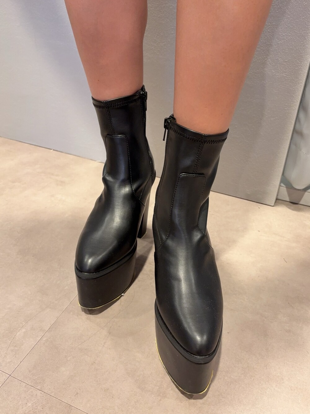 ホワイト系のニット/セーター、ブラック系のその他パンツ、ブラック系のブーツを着用したレディースの夏コーディネートの6枚目の写真