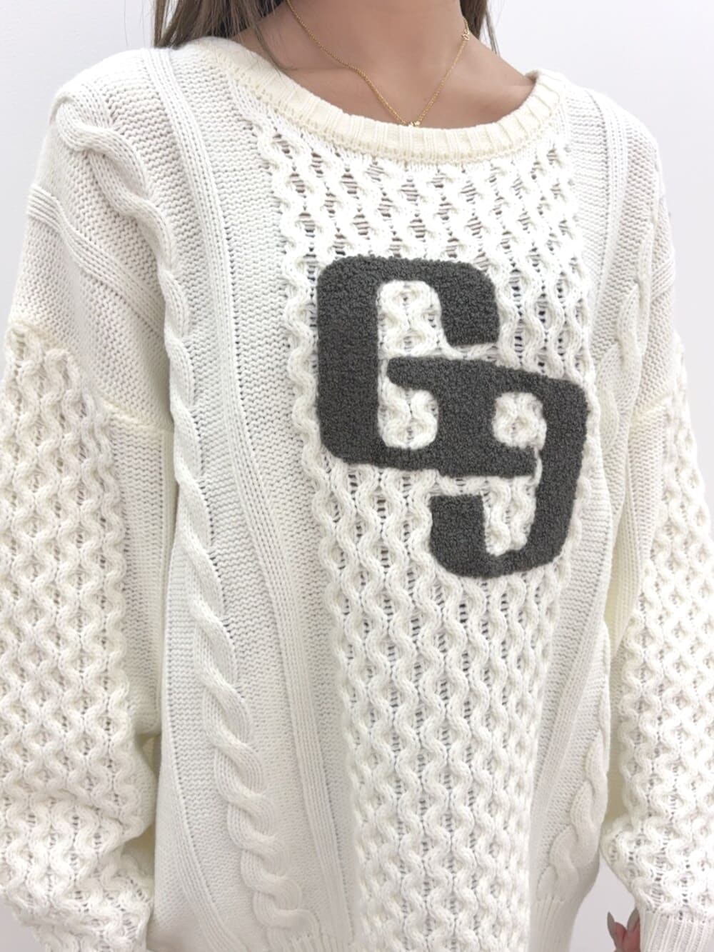 ブルー系のデニムパンツ、ベージュ系のブーツ、ホワイト系のニット/セーターを着用したレディースの秋コーディネートの4枚目の写真