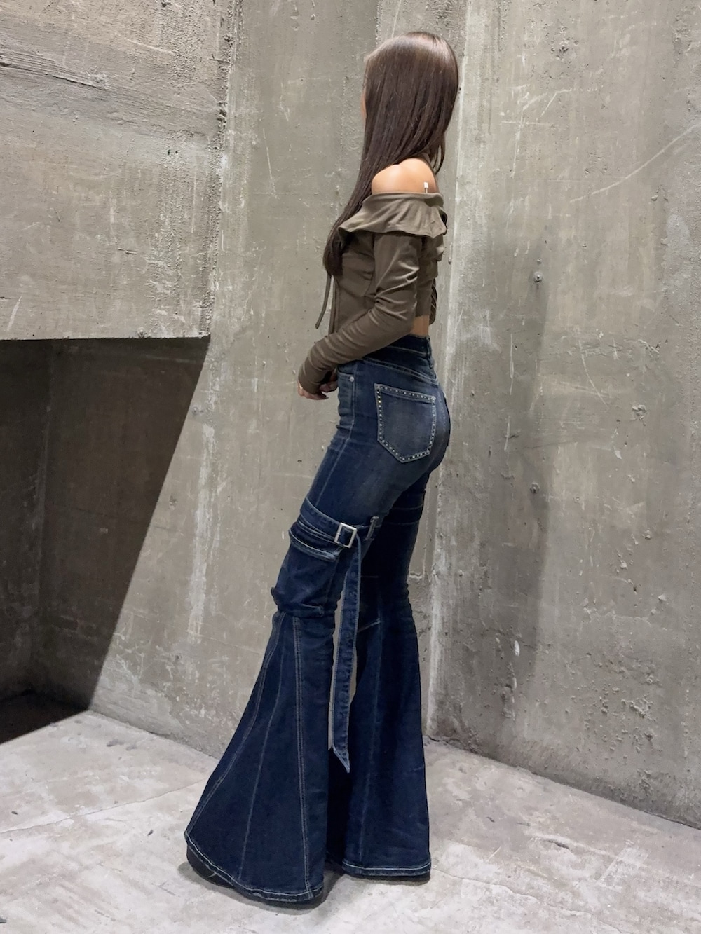 ブルー系のデニムパンツ、ブラック系のブーツ、グリーン系のTシャツ/カットソーを着用したレディースの夏コーディネートの2枚目の写真