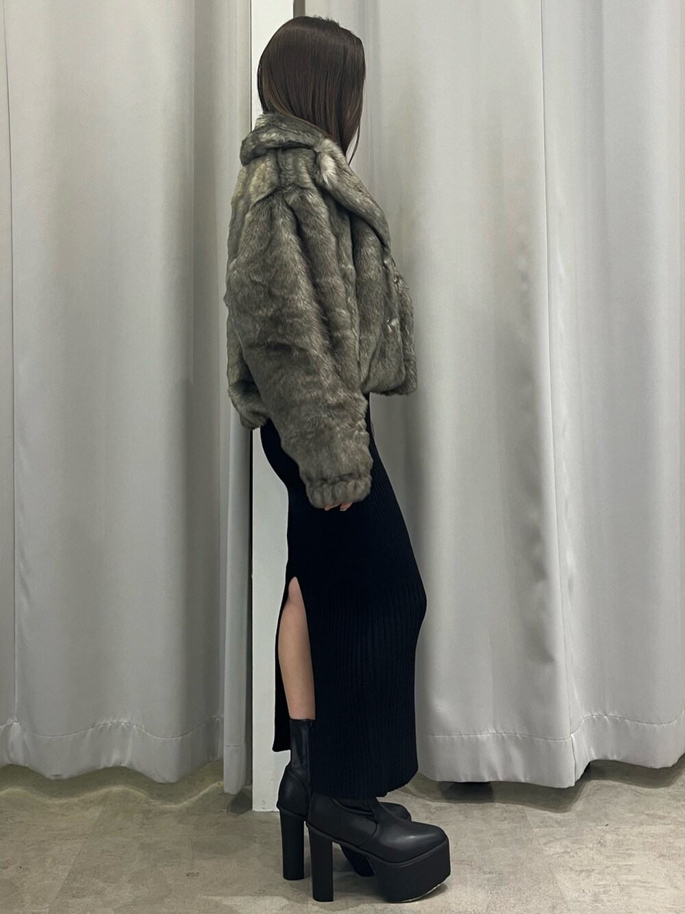 グレー系のその他アウター、ブラック系のワンピース、ブラック系のブーツを着用したレディースの秋コーディネートの2枚目の写真