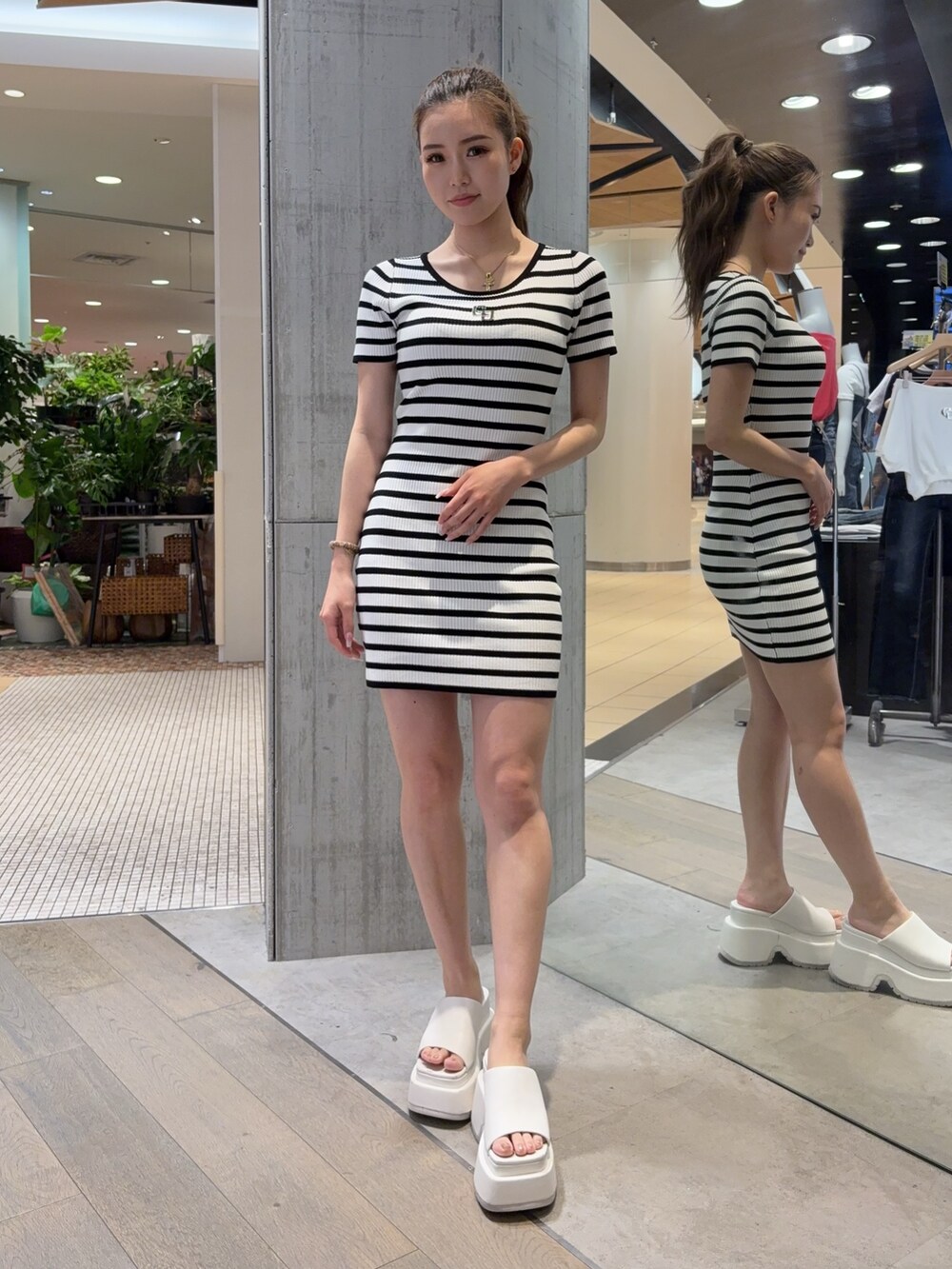 その他のワンピース、ブラック系のハンドバッグ、ホワイト系のサンダルを着用したレディースの春コーディネートの2枚目の写真