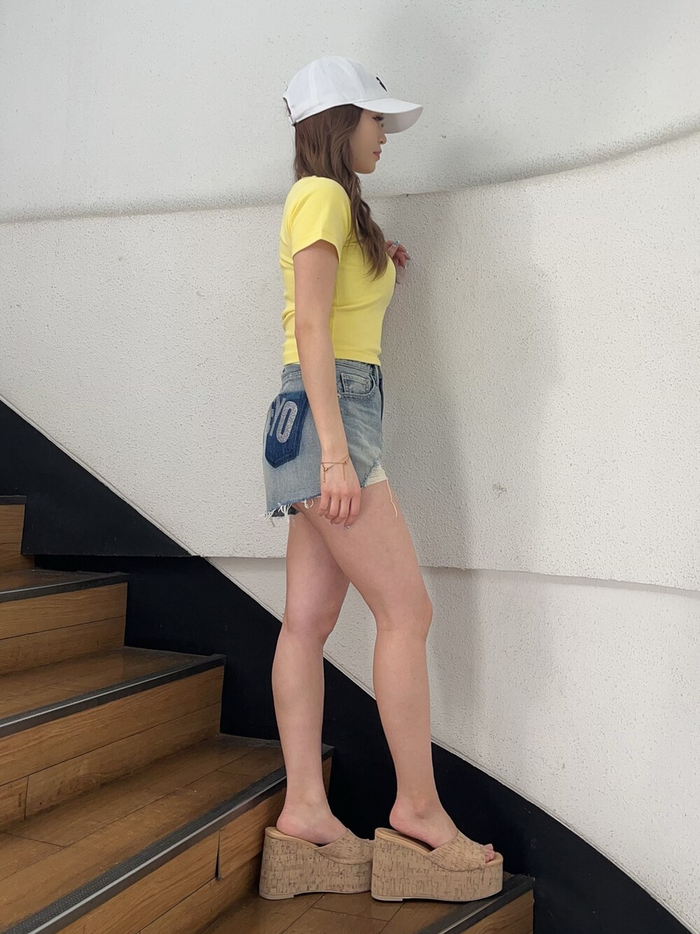 イエロー系のTシャツ/カットソー、ブルー系のデニムパンツ、ベージュ系のサンダルを着用したレディースの春コーディネートの2枚目の写真