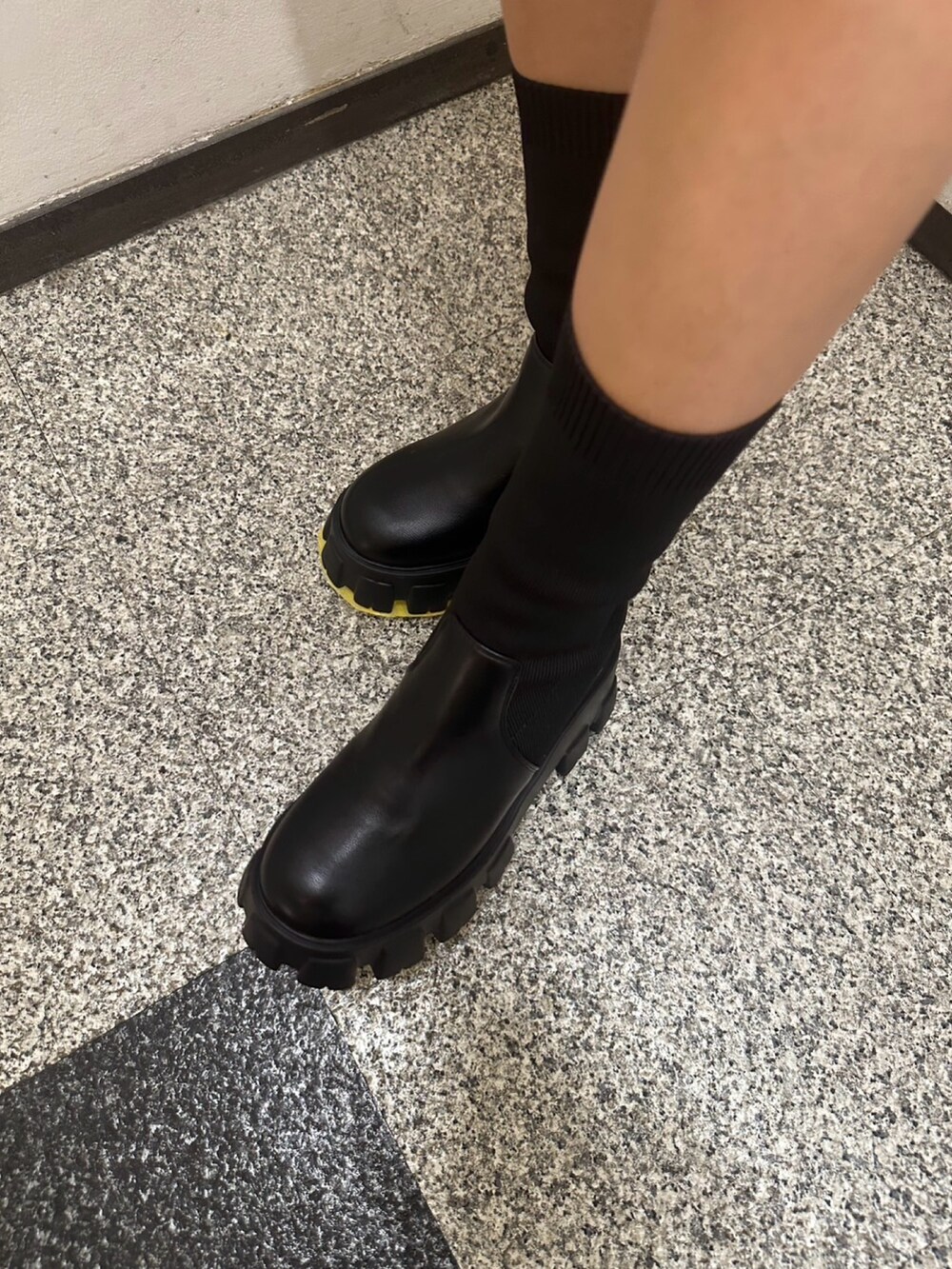 グレー系のニット/セーター、ブルー系のデニムスカート、ブラック系のブーツを着用したレディースの冬コーディネートの5枚目の写真