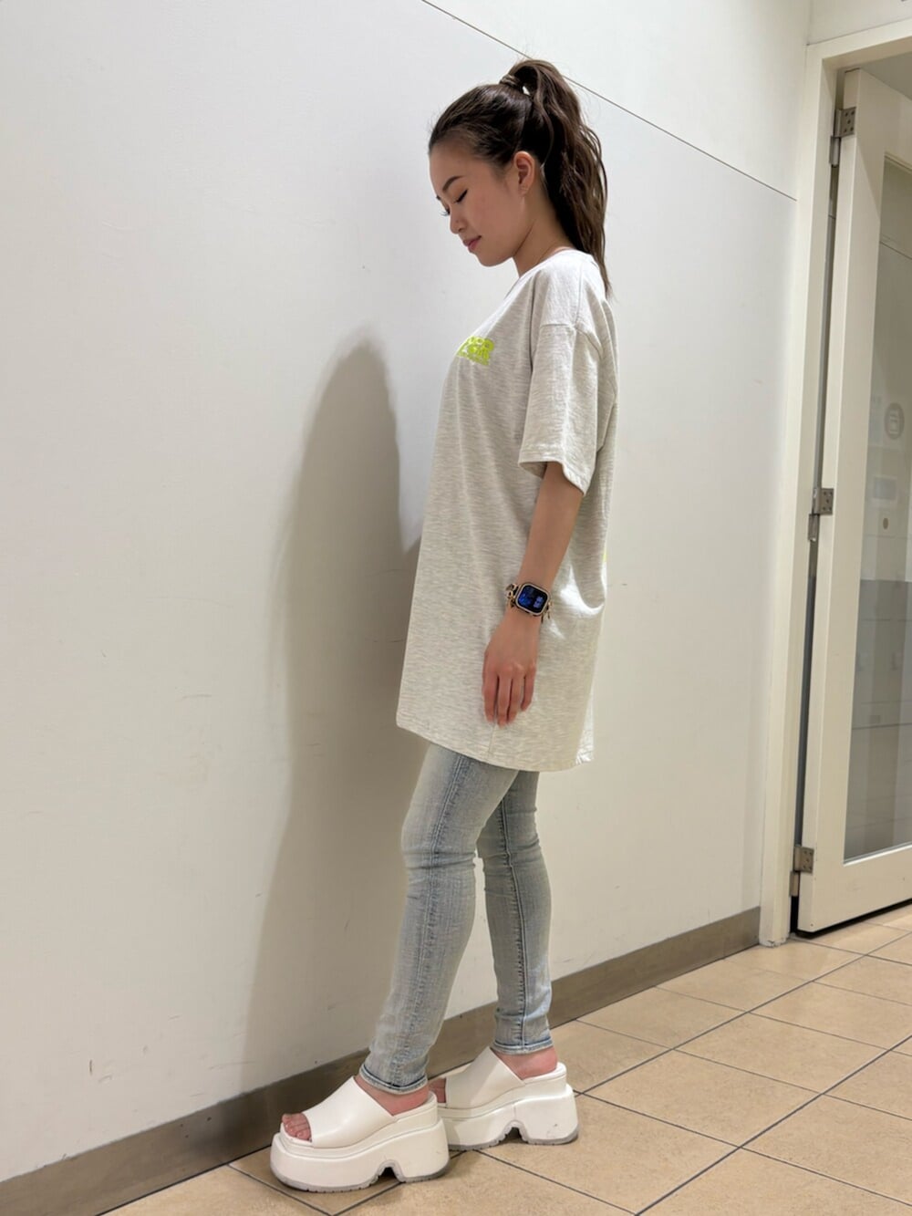 ホワイト系のサンダル、ブルー系のデニムパンツ、グレー系のTシャツ/カットソーを着用したレディースの春コーディネートの2枚目の写真