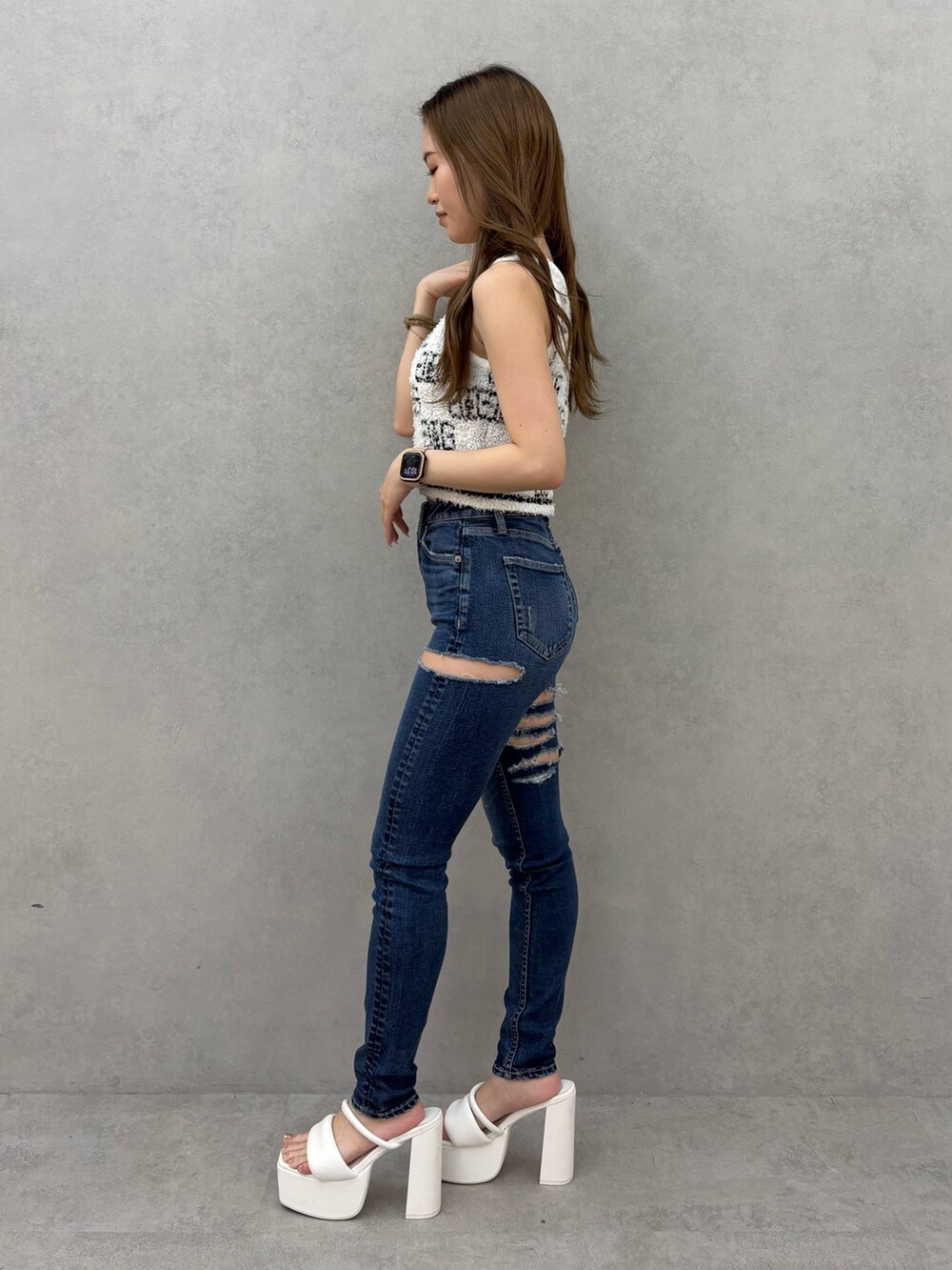 ホワイト系のニット/セーター、ブルー系のデニムパンツ、ホワイト系のサンダルを着用したレディースの夏コーディネートの2枚目の写真