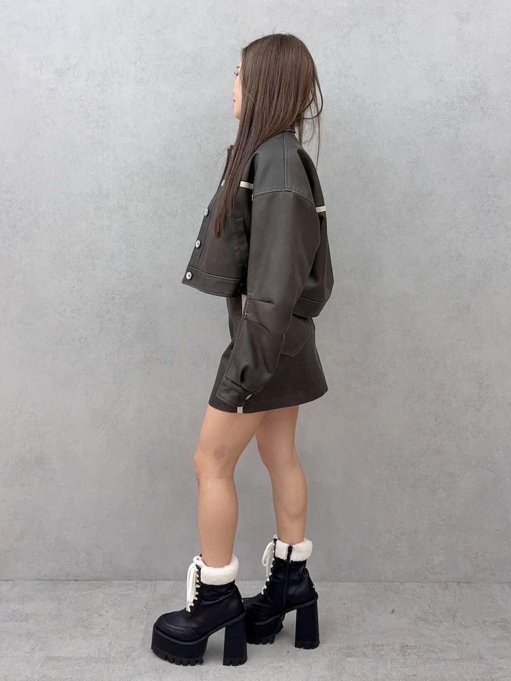 ホワイト系のTシャツ/カットソー、ブラック系のブーツ、ブラウン系のブルゾンを着用したレディースの冬コーディネートの2枚目の写真