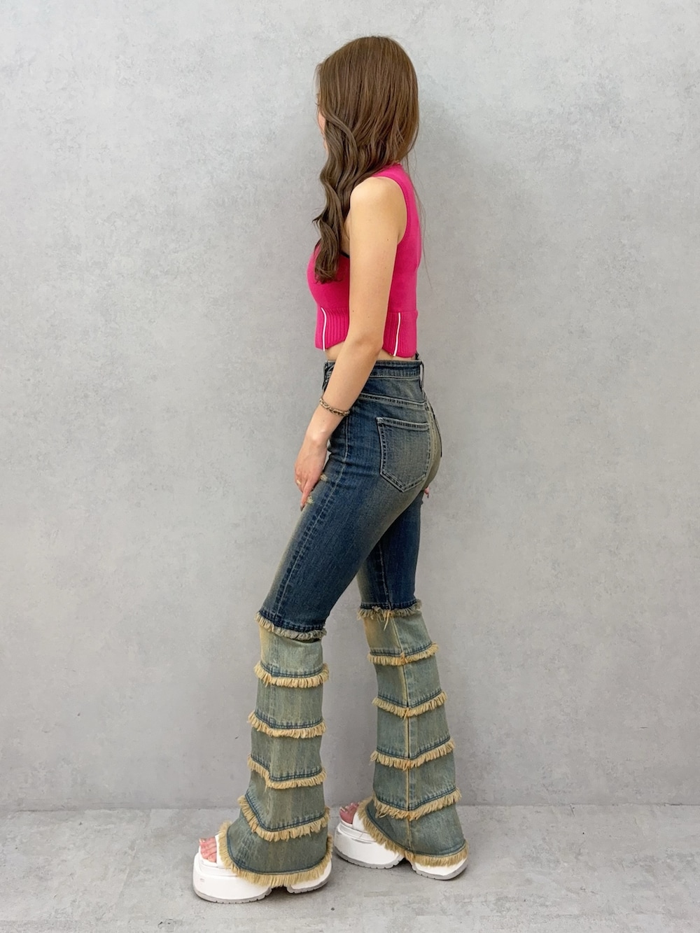 ブルー系のデニムパンツ、ホワイト系のサンダル、ピンク系のニット/セーターを着用したレディースの夏コーディネートの2枚目の写真