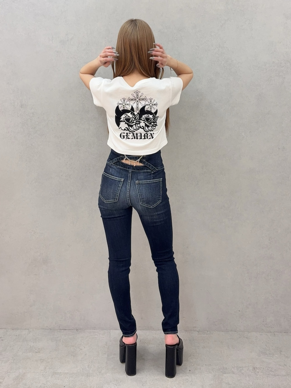 ブルー系のデニムパンツ、ブラック系のサンダル、ホワイト系のTシャツ/カットソーを着用したレディースの春コーディネートの3枚目の写真