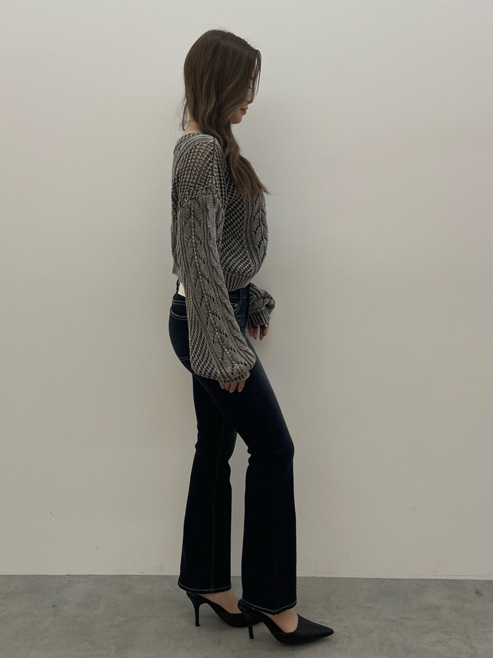 ブルー系のニット/セーター、ブルー系のデニムパンツ、ブラック系のパンプスを着用したレディースの春コーディネートの2枚目の写真
