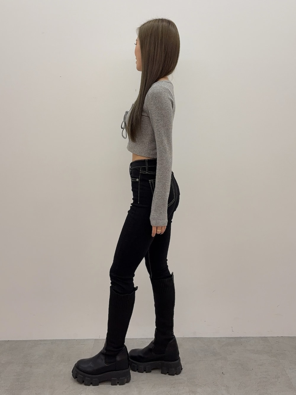 グレー系のTシャツ/カットソー、ブラック系のデニムパンツ、ブラック系のブーツを着用したレディースの秋コーディネートの2枚目の写真