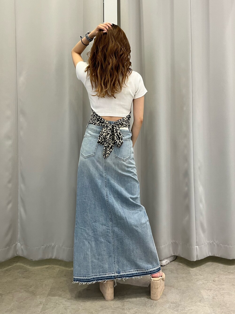 ホワイト系のTシャツ/カットソー、ブルー系のデニムスカート、ホワイト系のサンダルを着用したレディースの夏コーディネートの3枚目の写真