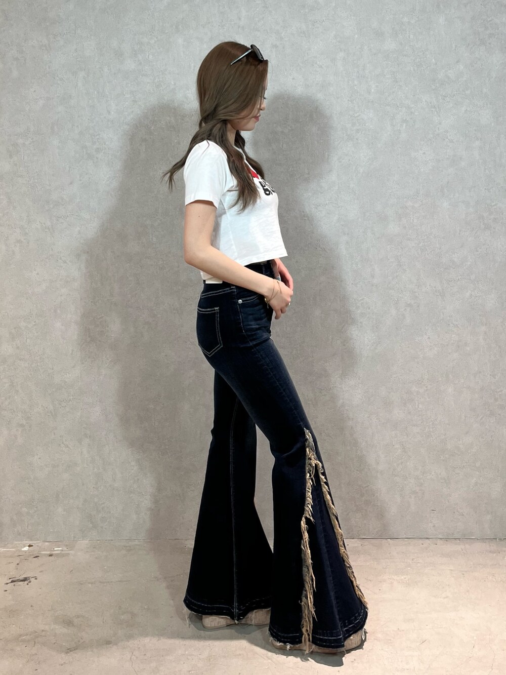 ホワイト系のTシャツ/カットソー、ブルー系のデニムパンツ、ホワイト系のサンダルを着用したレディースの春コーディネートの2枚目の写真