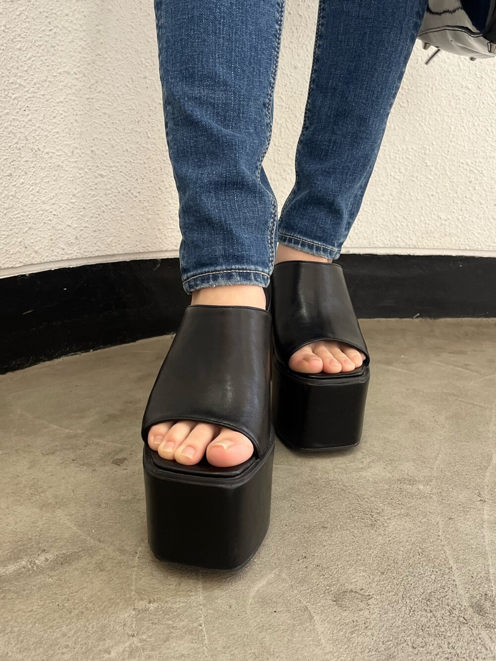 ブルー系のデニムパンツ、ブラック系のサンダル、ホワイト系のキャミソールを着用したレディースの夏コーディネートの5枚目の写真