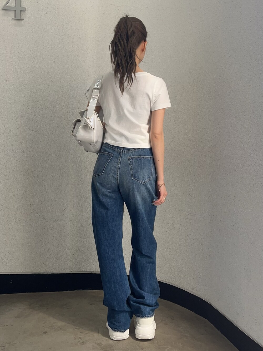 ホワイト系のTシャツ/カットソー、ホワイト系のハンドバッグ、ブルー系のデニムパンツを着用したレディースの春コーディネートの3枚目の写真