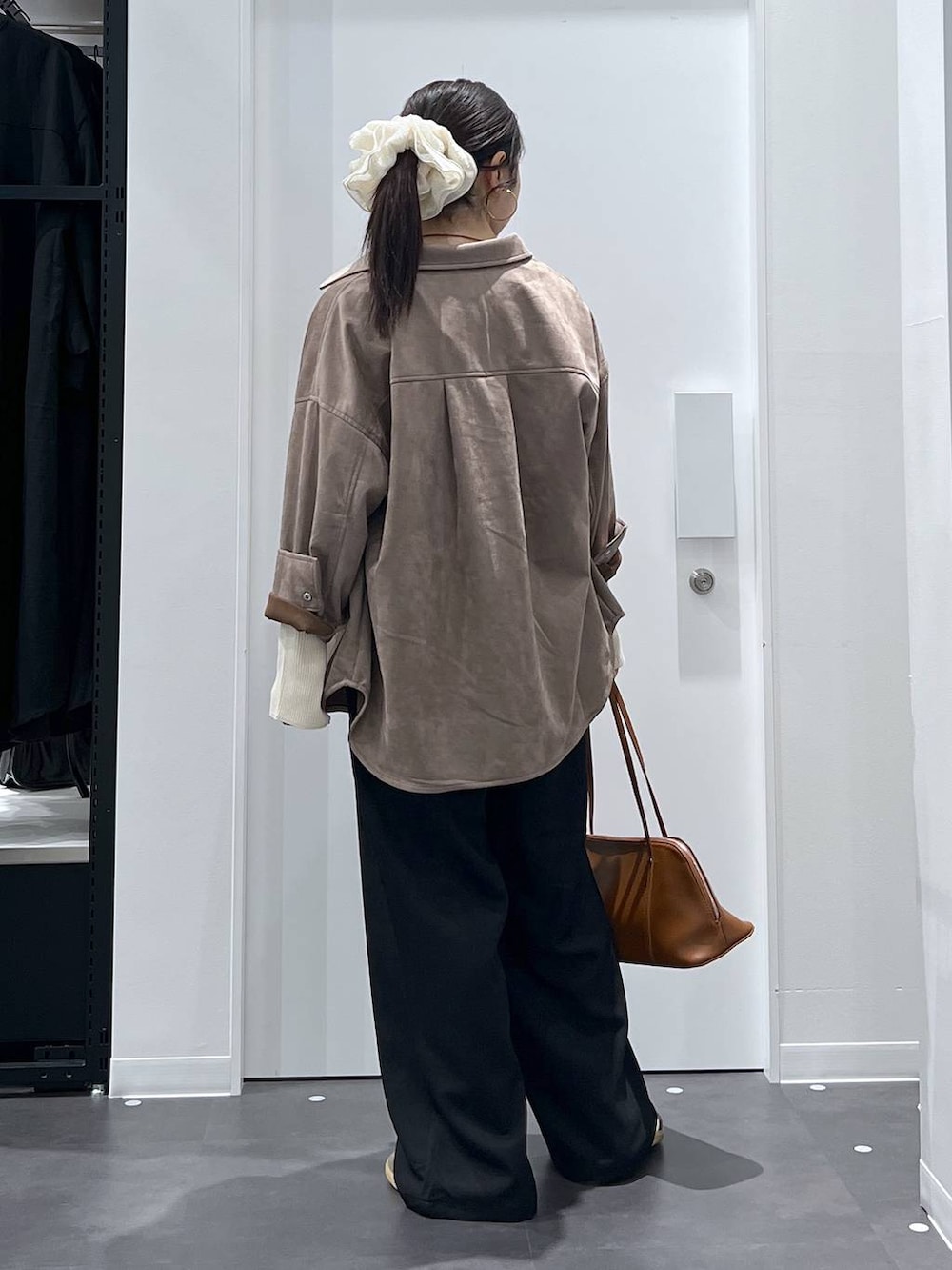 ブラウン系のボストンバッグ、ベージュ系のニット/セーター、ブラック系のその他パンツを着用したレディースの秋コーディネートの3枚目の写真