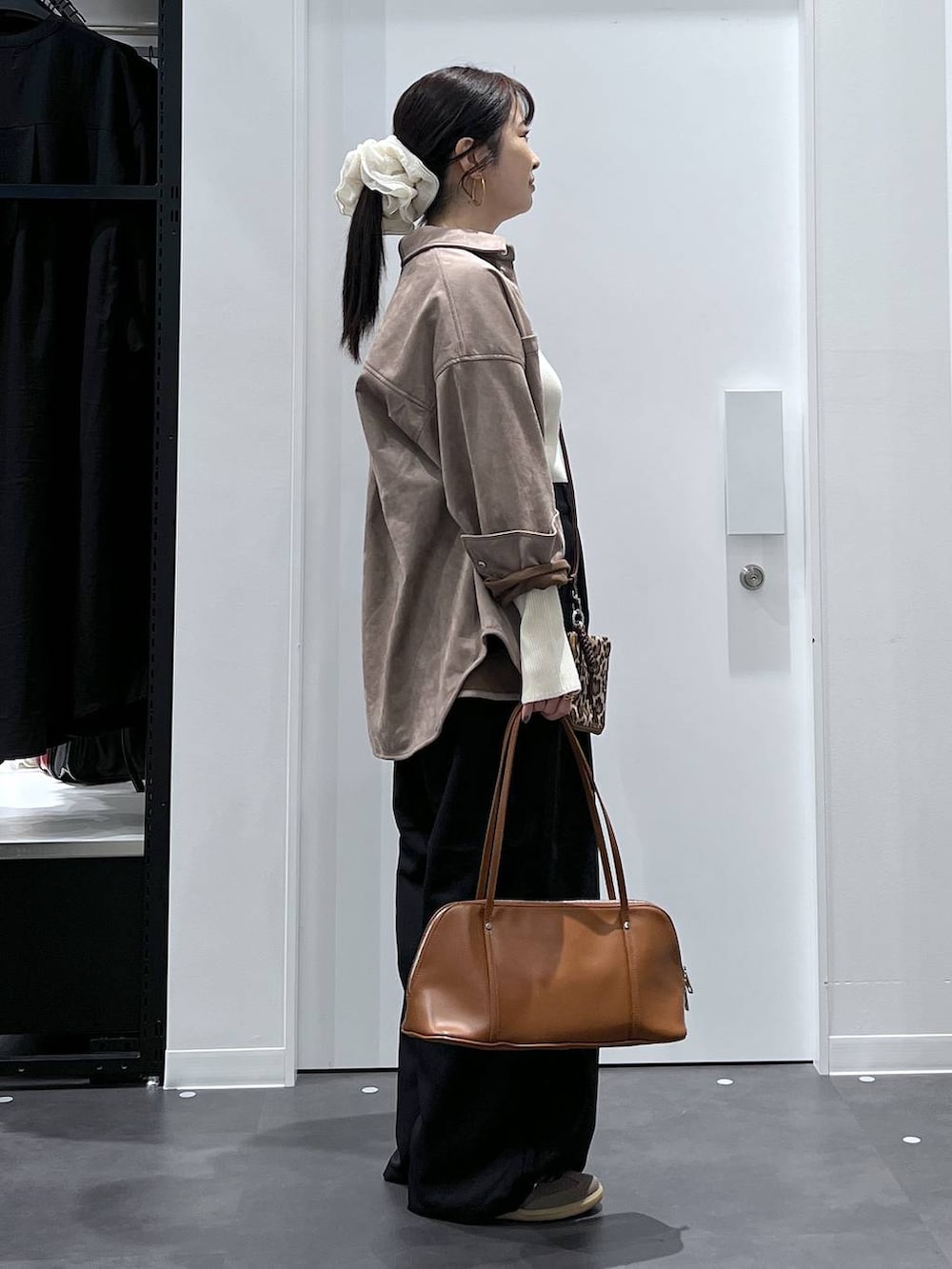 ブラウン系のボストンバッグ、ベージュ系のニット/セーター、ブラック系のその他パンツを着用したレディースの秋コーディネートの2枚目の写真