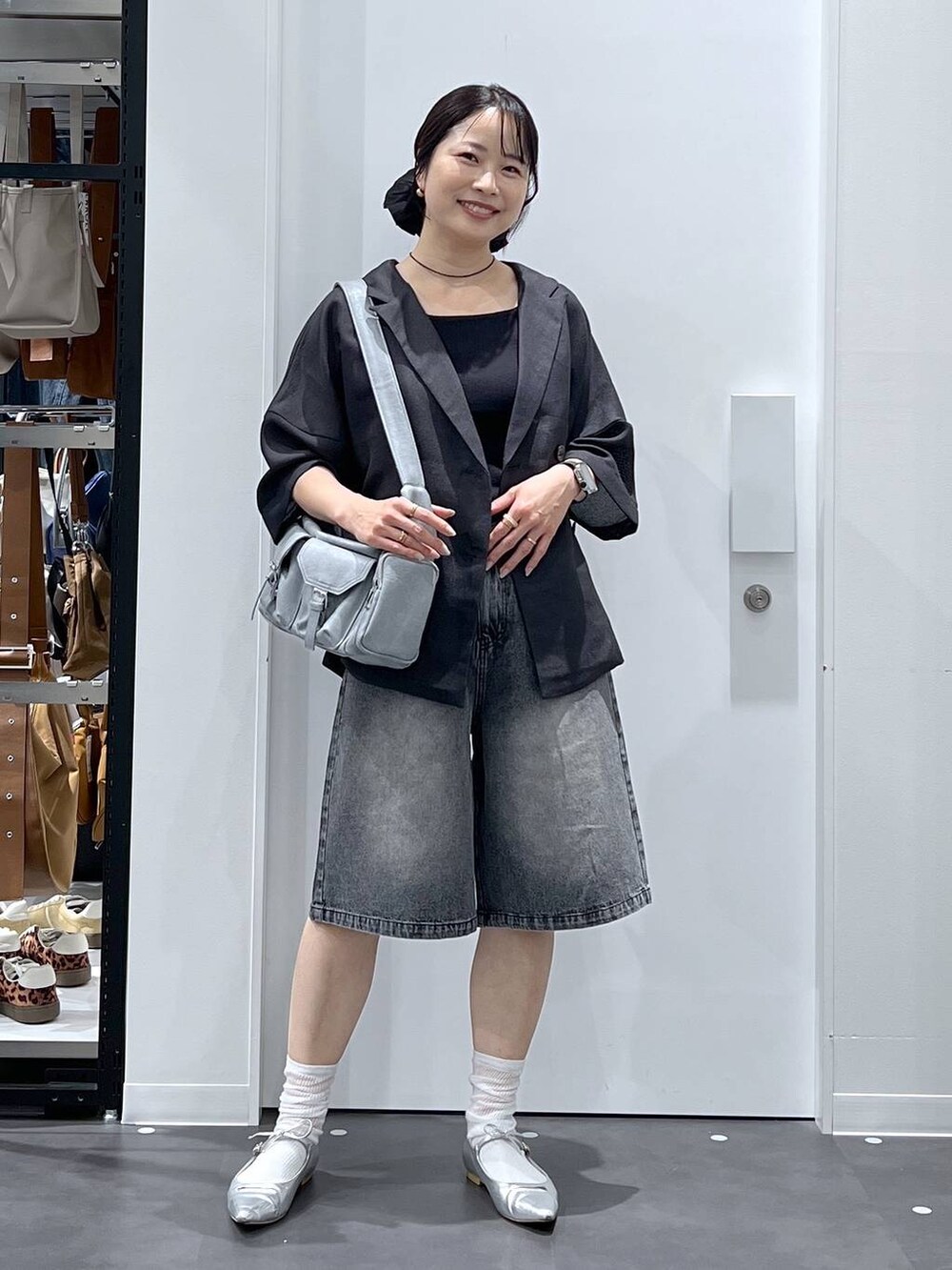 シルバー系のパンプス、グレー系のショルダーバッグ、グレー系のテーラードジャケットを着用したレディースの夏コーディネートの4枚目の写真