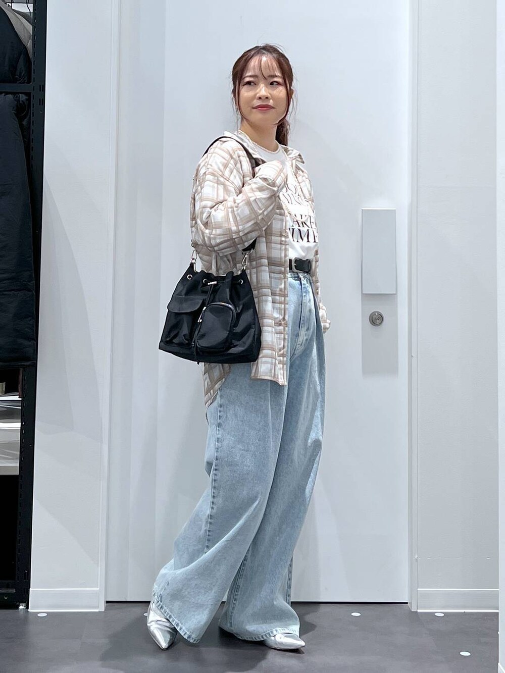 ブルー系のデニムパンツ、シルバー系のパンプス、ホワイト系のTシャツ/カットソーを着用したレディースの春コーディネートの3枚目の写真