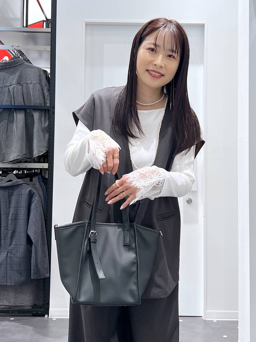 ブラック系のレインシューズ、ブラック系のトートバッグ、グレー系のベストを着用したレディースの冬コーディネートの5枚目の写真