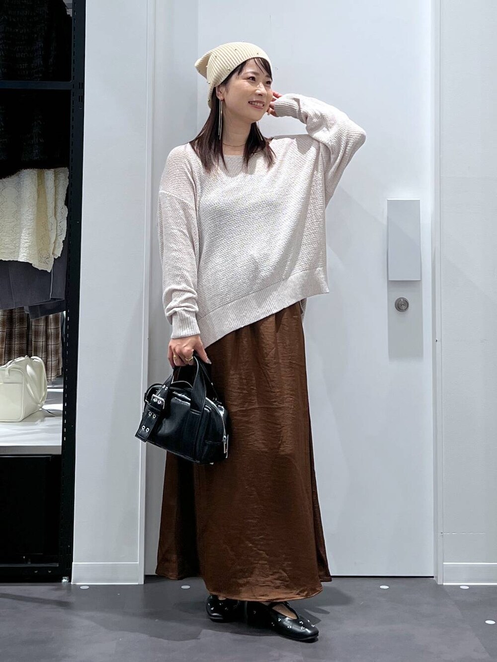 ブラック系のパンプス、ブラック系のショルダーバッグ、ブラウン系のスカートを着用したレディースの夏コーディネートの8枚目の写真