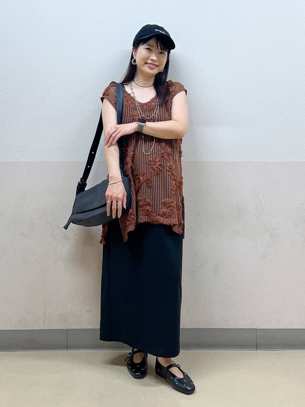 ブラック系のスカート、ブラック系のパンプス、ブラック系のショルダーバッグを着用したレディースの夏コーディネートの5枚目の写真