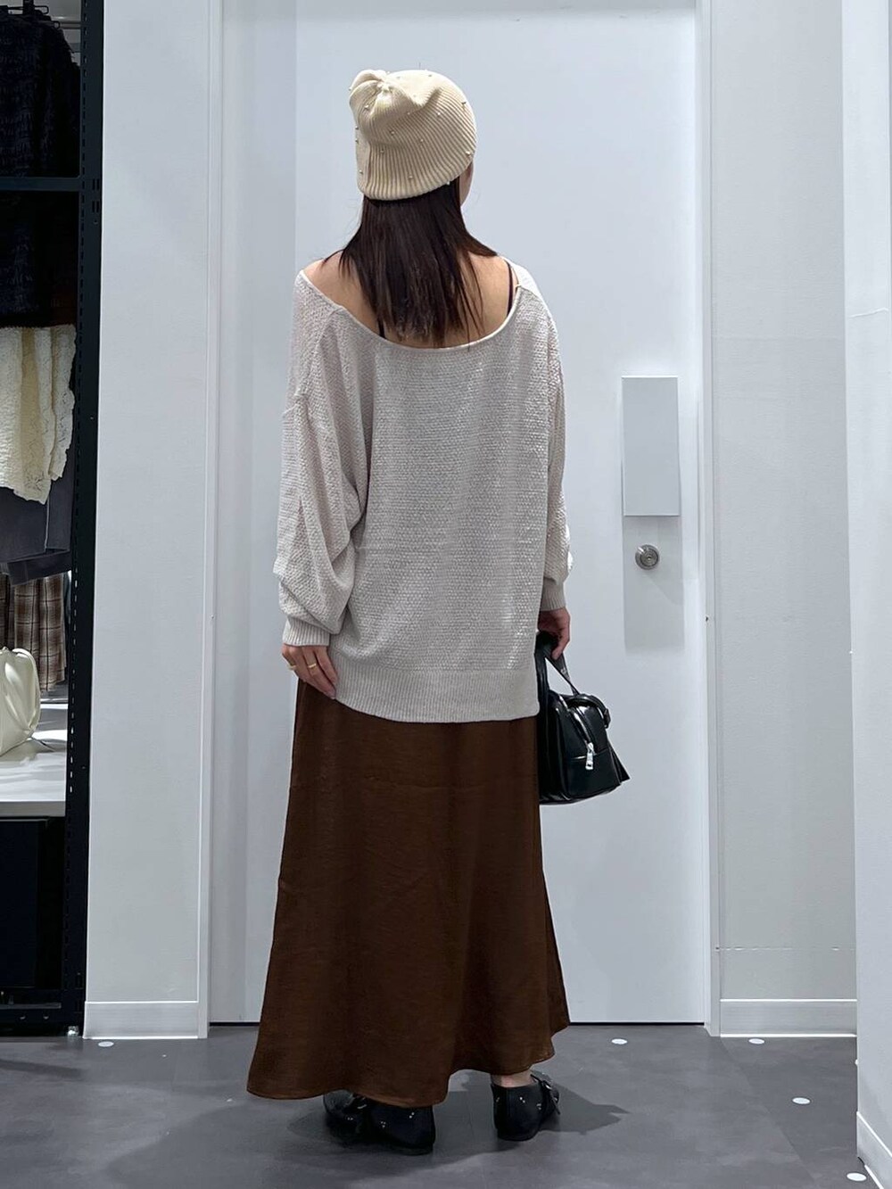 ブラック系のパンプス、ブラック系のショルダーバッグ、ブラウン系のスカートを着用したレディースの夏コーディネートの3枚目の写真