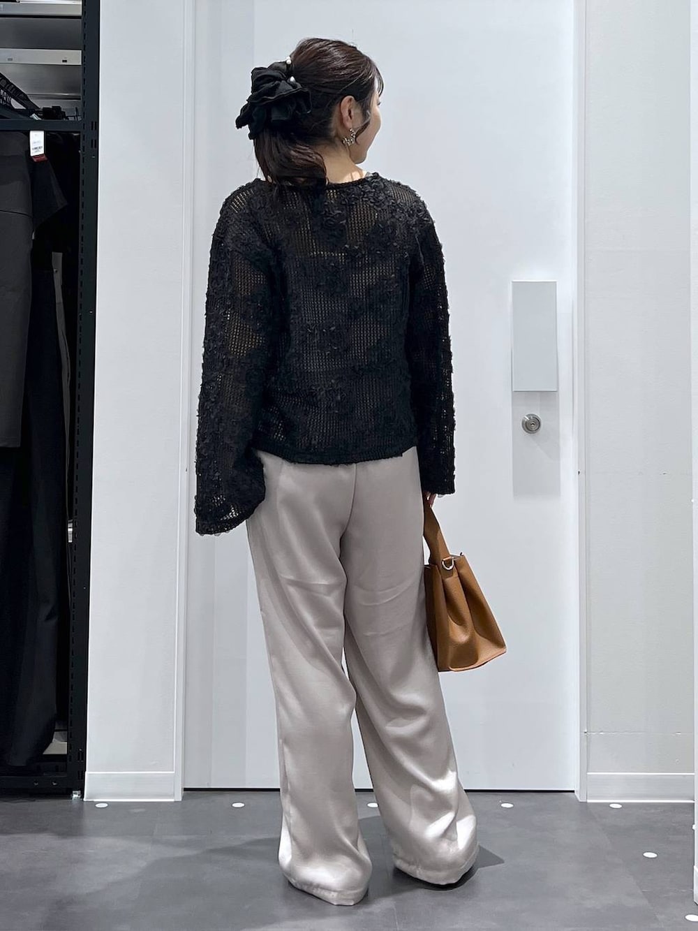 シルバー系のパンプス、ブラック系のシャツ/ブラウス、ブラウン系のトートバッグを着用したレディースの春コーディネートの3枚目の写真