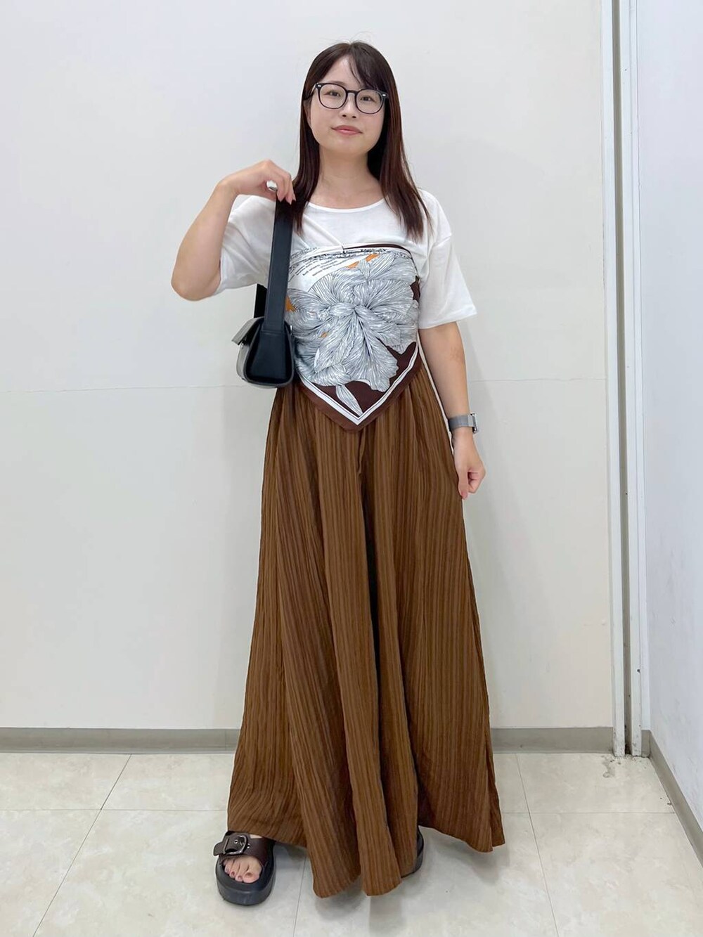 ホワイト系のTシャツ/カットソー、ブラック系のショルダーバッグ、ブラウン系のその他パンツを着用したレディースの秋コーディネートの4枚目の写真