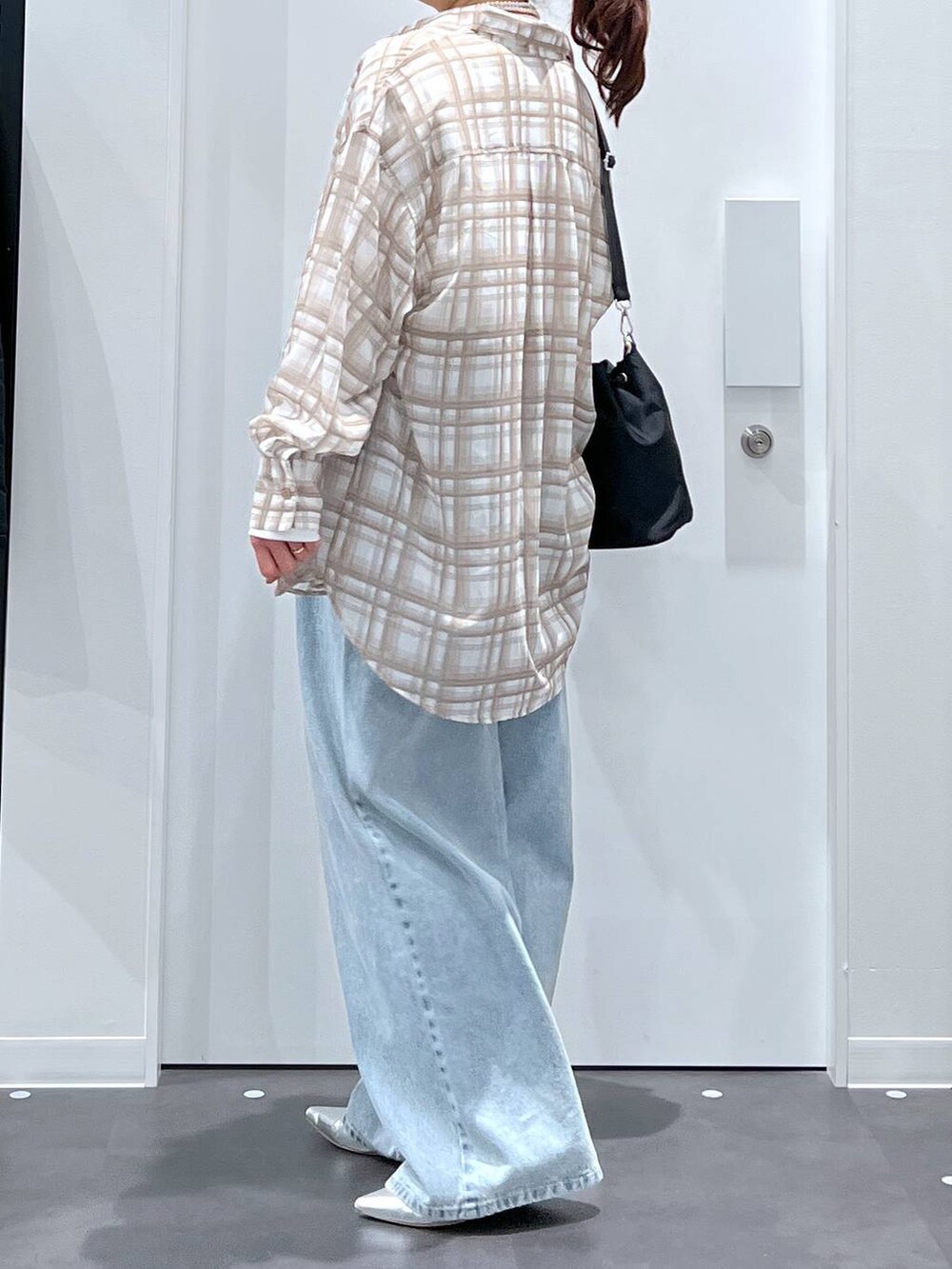 ブルー系のデニムパンツ、シルバー系のパンプス、ホワイト系のTシャツ/カットソーを着用したレディースの春コーディネートの2枚目の写真